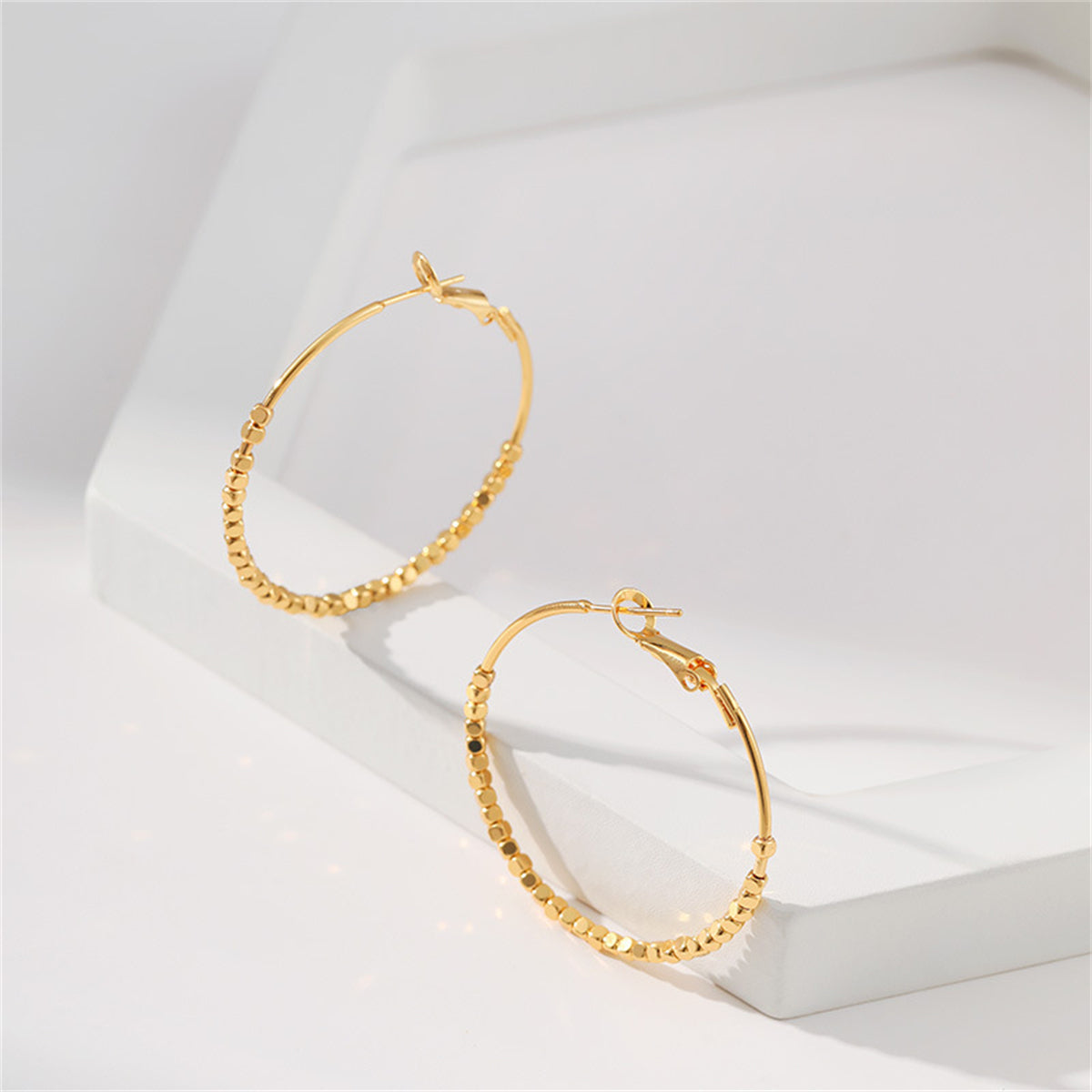 Beautiful 18K gold-plated hoop earrings with unique cube bead accents, ideal for elevating your jewelry collection.