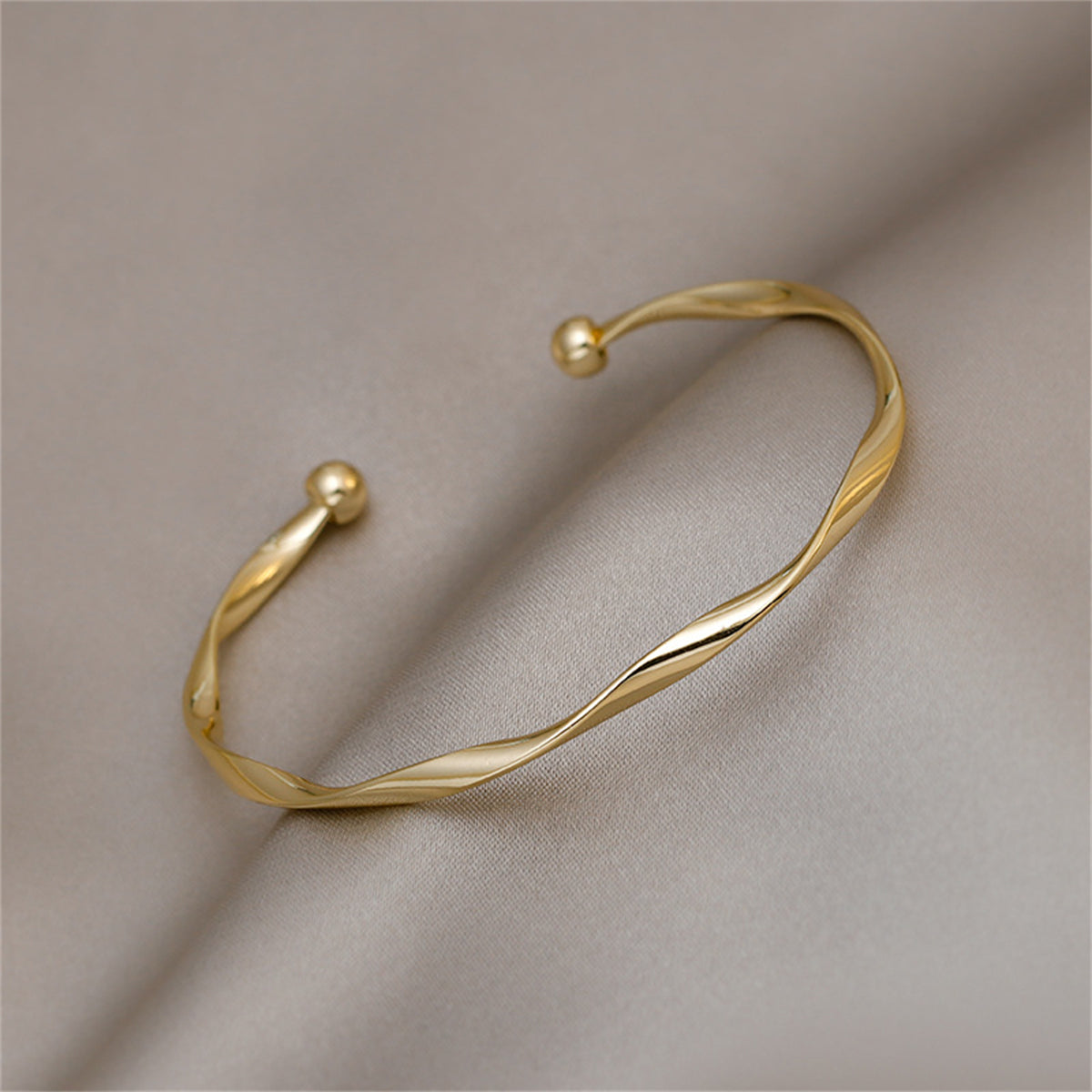 Beautifully crafted 18K gold-plated cuff bracelet showcasing a twisted design, a must-have accessory for any fashion lover.