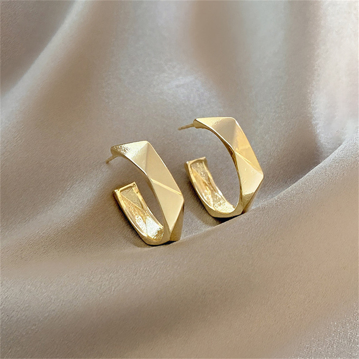 Stunning 18K gold-plated diamond-cut hoop earrings showcasing chic geometric designs for a fashionable statement.