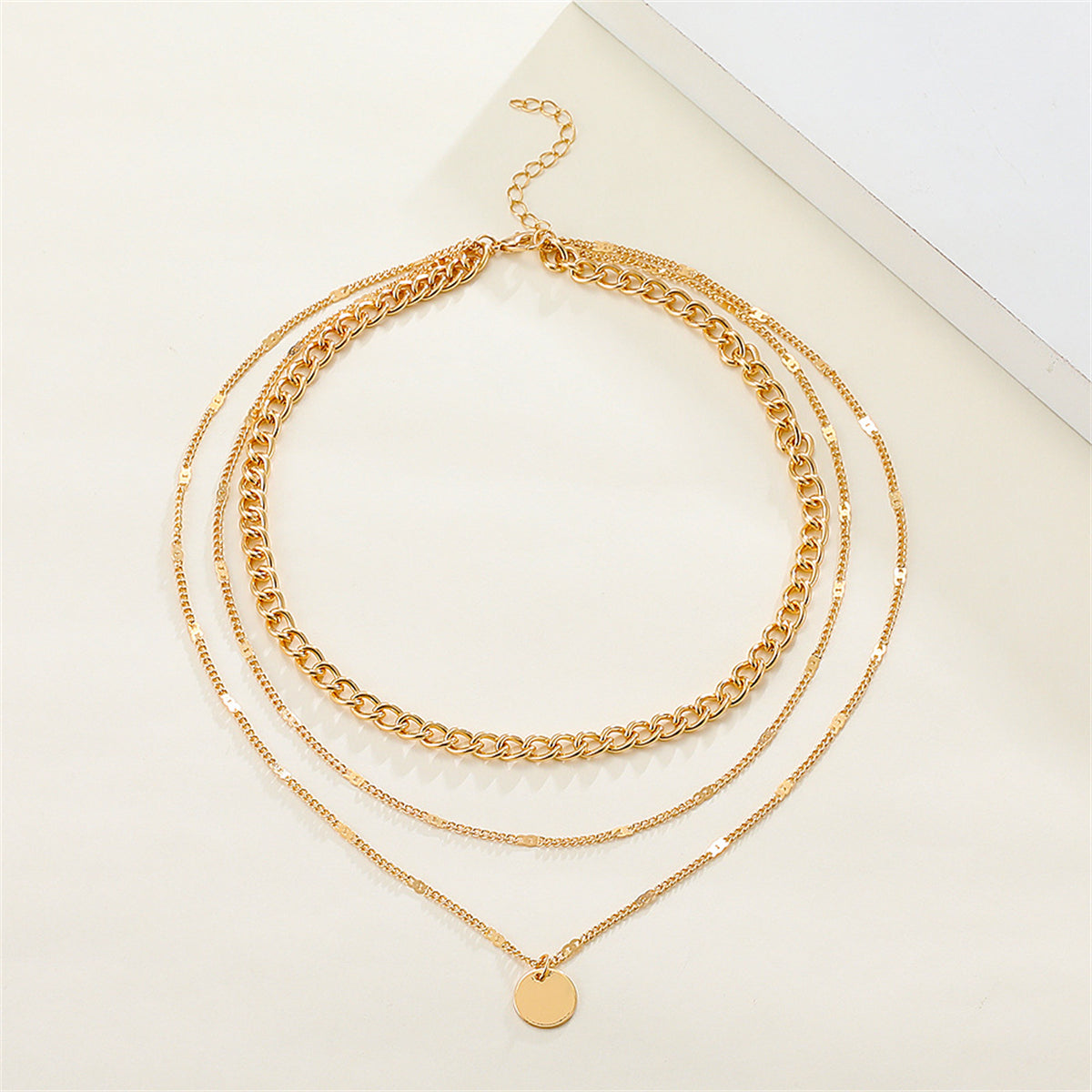 Fashionable 18K gold-plated Cuban chain necklace with three layers and a disc charm, perfect for a trendy statement look.