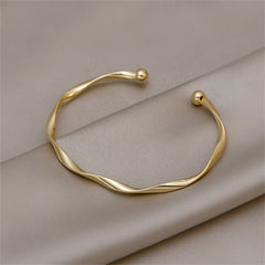 Stunning 18K gold-plated bracelet with a twisted wave design, ideal for elevating your jewelry collection with style.