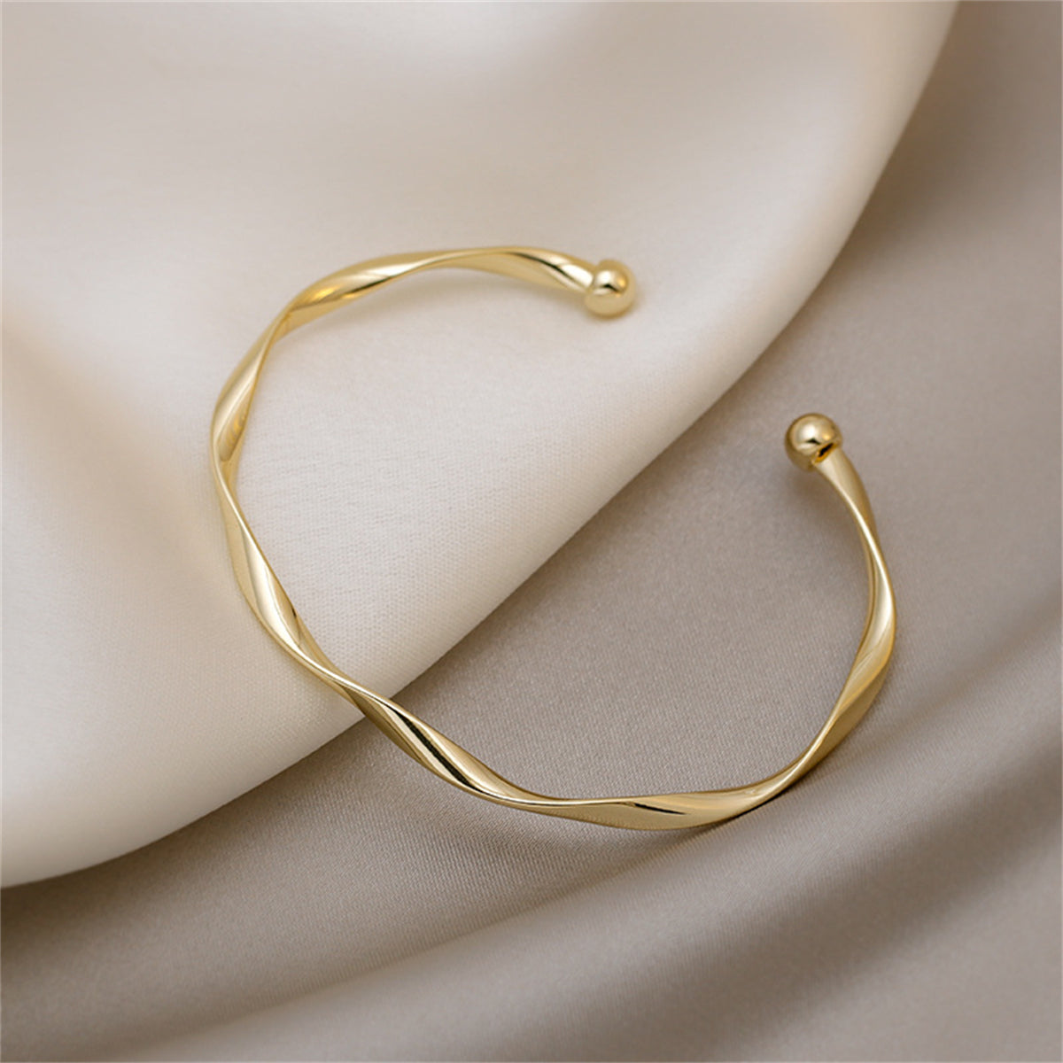 Chic 18K gold-plated bracelet with a stylish twisted design, perfect for making a statement in any jewelry ensemble.