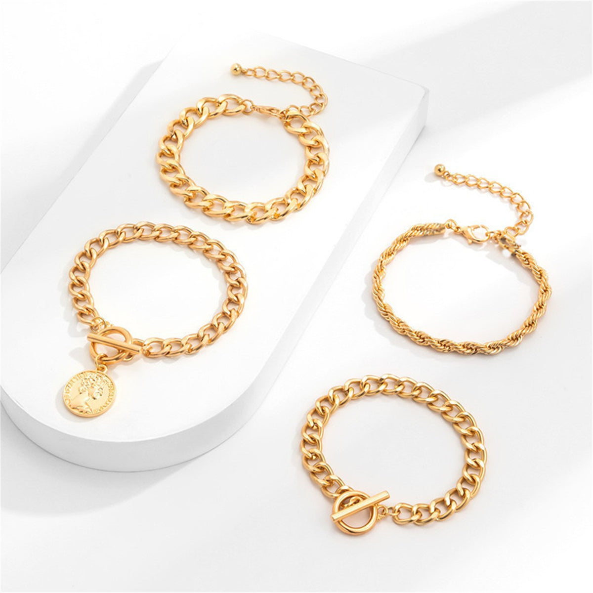 A stunning set of four gold chain bracelets, each adorned with a unique charm, showcasing 18K gold-plated elegance.