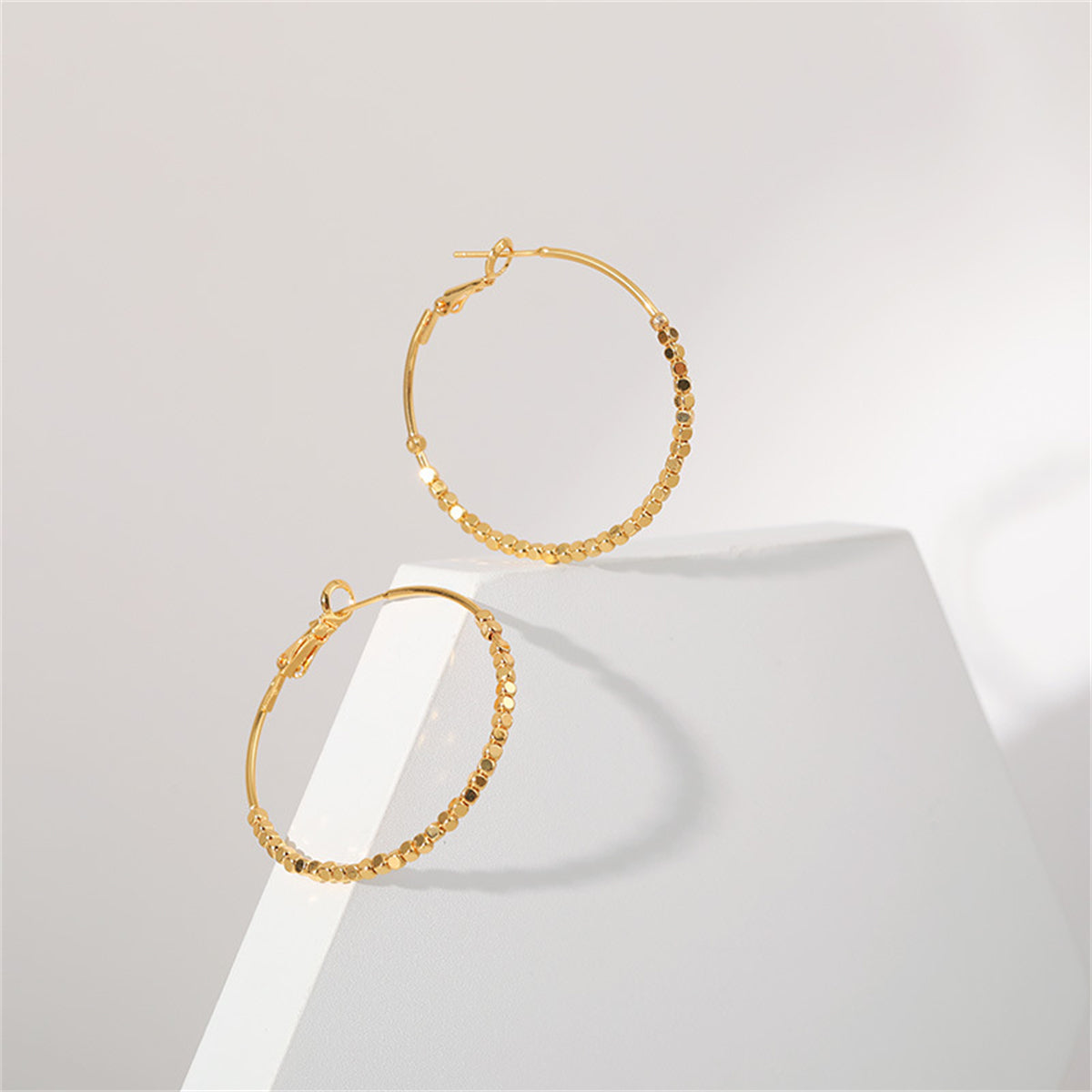 Dazzling 18K gold-plated hoop earrings embellished with cube beads, a fashionable choice for any jewelry lover.