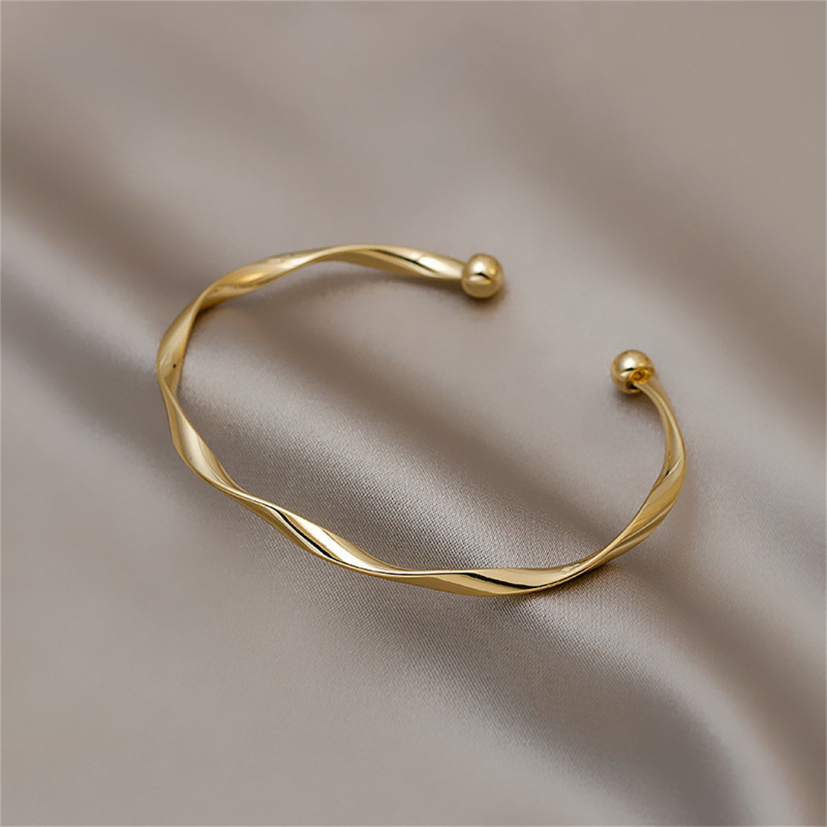 Elegant 18K gold-plated cuff bracelet featuring a unique twisted design, perfect for adding sophistication to any outfit.