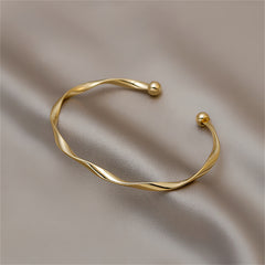 Elegant 18K gold-plated cuff bracelet featuring a unique twisted design, perfect for adding sophistication to any outfit.