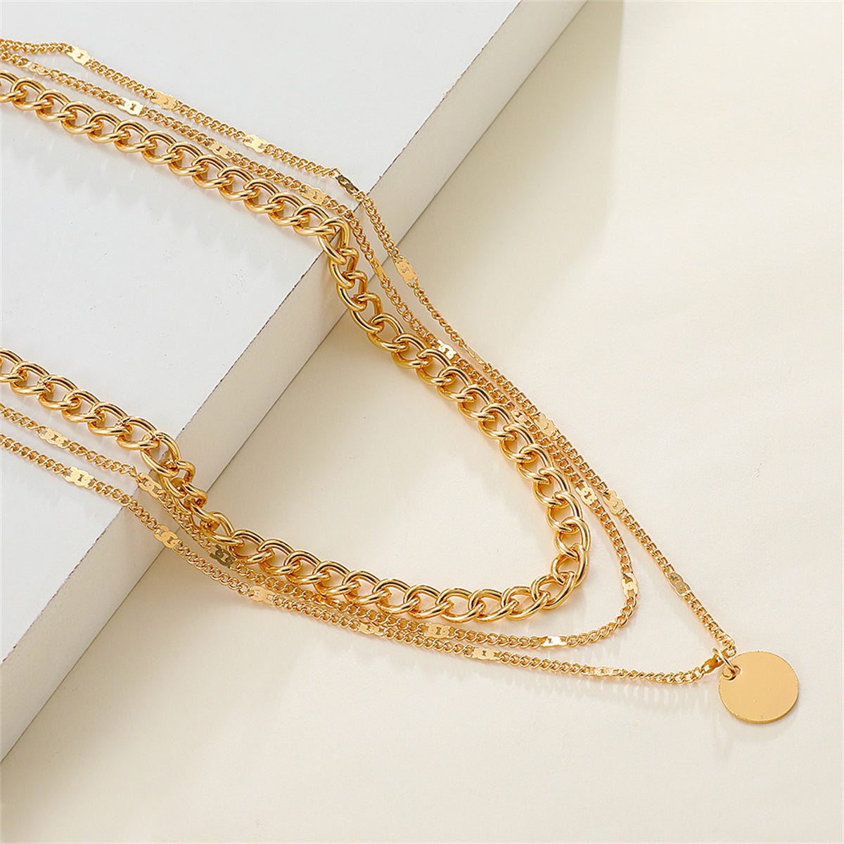 Chic three-layer necklace in 18K gold plating, adorned with a disc charm, ideal for elevating your jewelry collection.