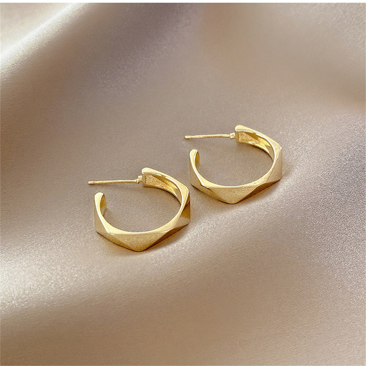 Eye-catching 18K gold-plated diamond-cut hoop earrings designed with contemporary geometric patterns for a stylish look.