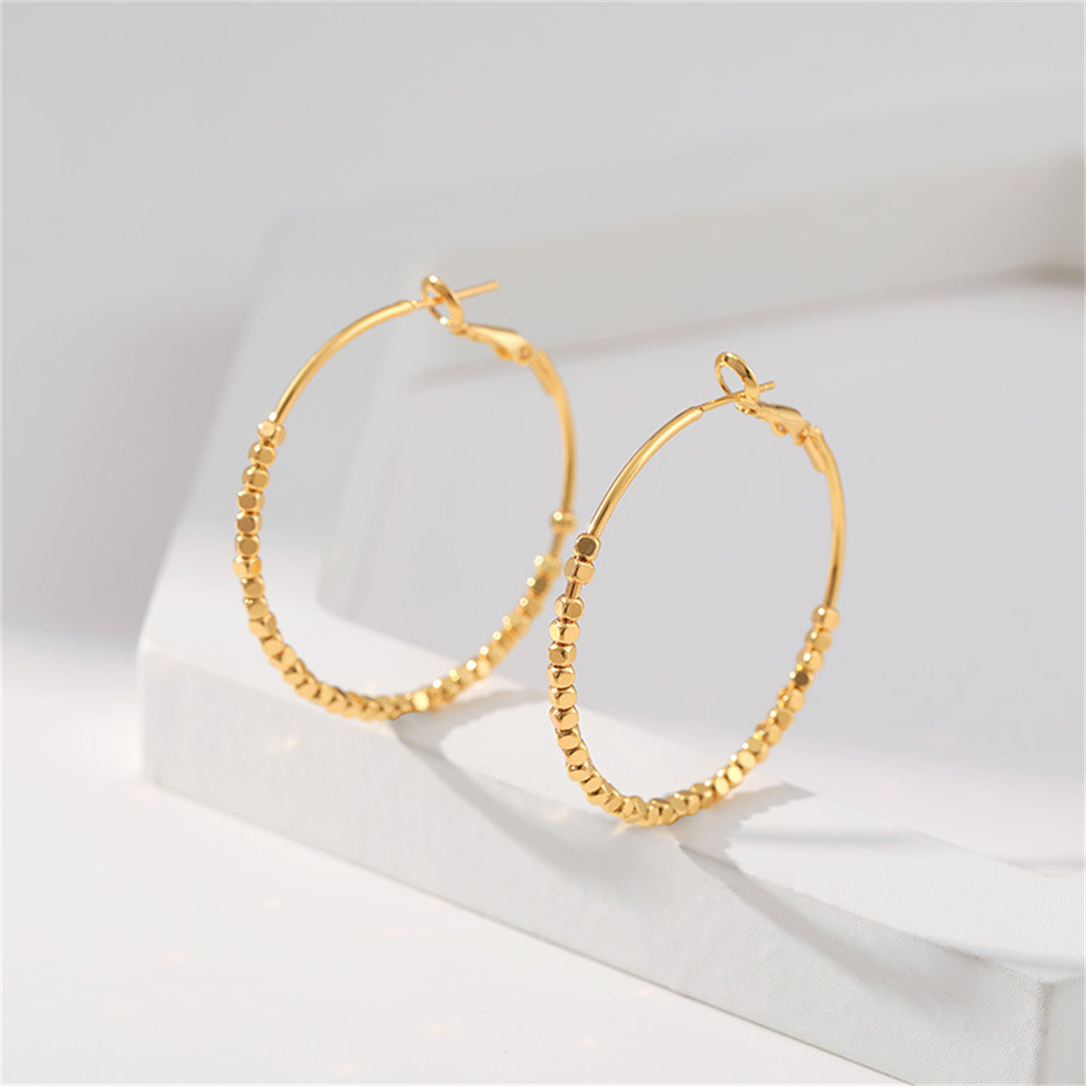 Elegant 18K gold-plated hoop earrings adorned with stylish cube beads, perfect for any occasion.