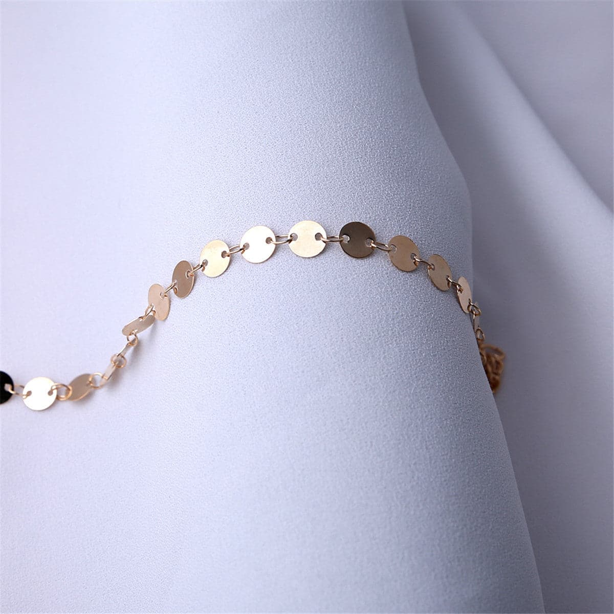 Dazzling 18K gold-plated anklet with a mariner chain and disc charm, adding a touch of elegance to your ensemble.