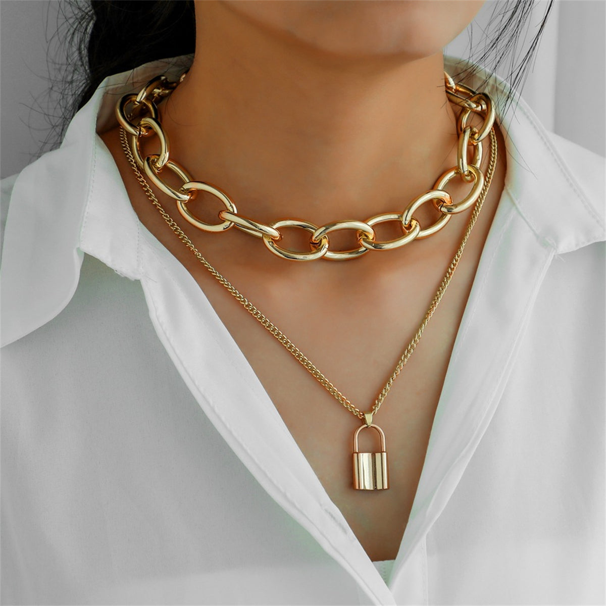 Elegant 18K gold-plated layered necklace featuring a stylish padlock pendant on a delicate cable chain.