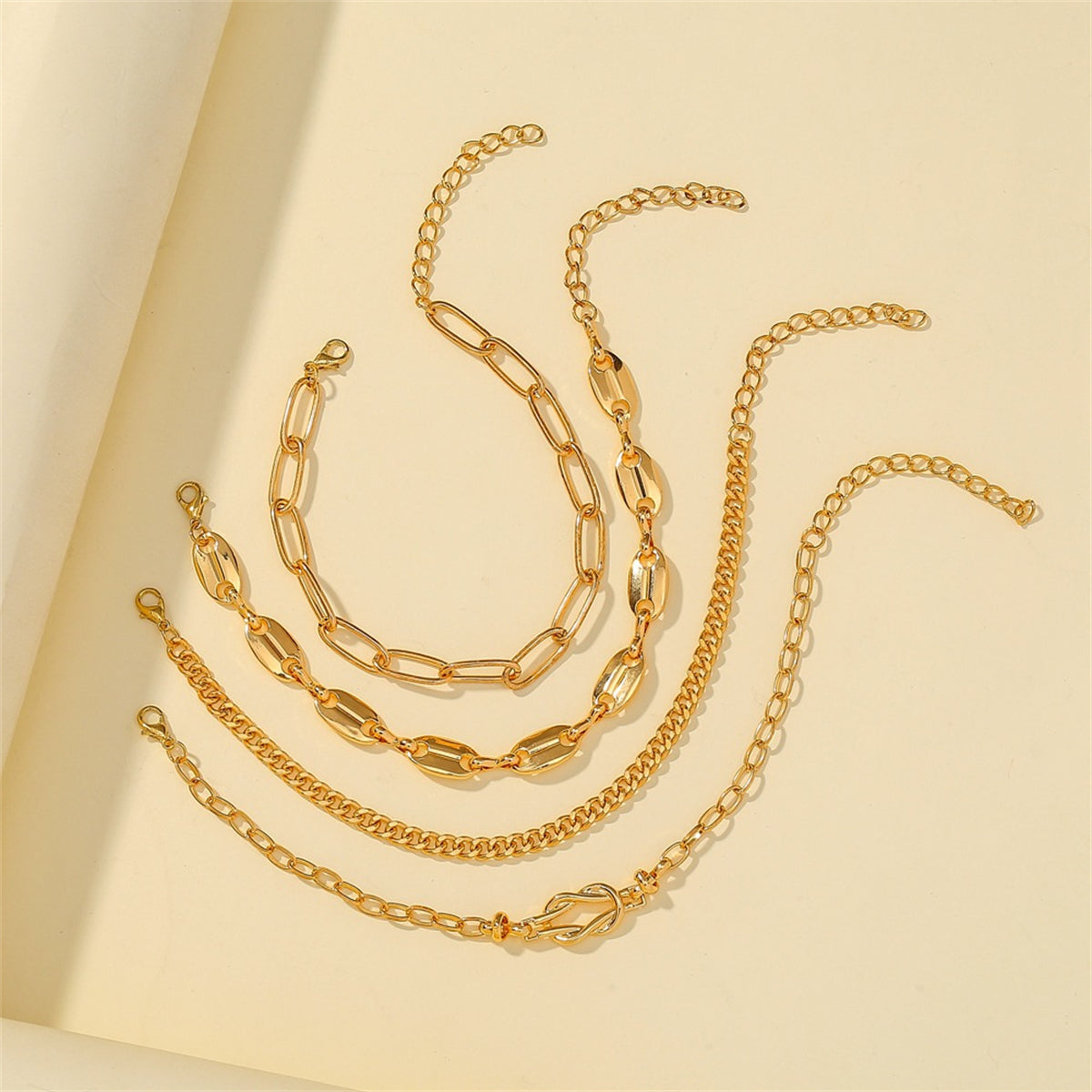 A beautiful collection of four 18K gold-plated chain bracelets, each with a secure clasp and intricate chain work.