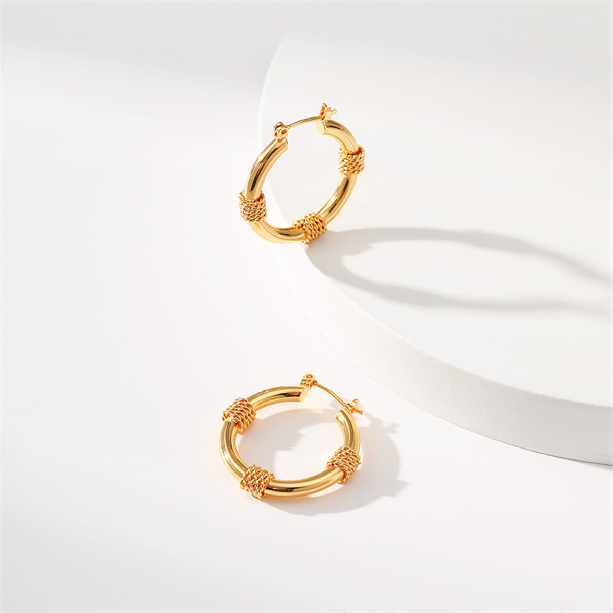 Beautifully crafted 18K gold-plated huggie earrings showcasing a twisted rope pattern, a must-have for any jewelry collection.