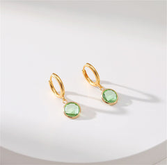 Stunning gold-plated huggie earrings with light green stones, combining elegance and modern design.