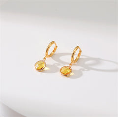 Beautiful yellow gold-plated huggie earrings with a round cut yellow crystal, ideal for enhancing any outfit.