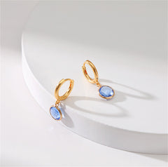 Beautiful gold-tone huggie earrings with blue topaz stones and purple crystals, designed in luxurious 18K gold plating.