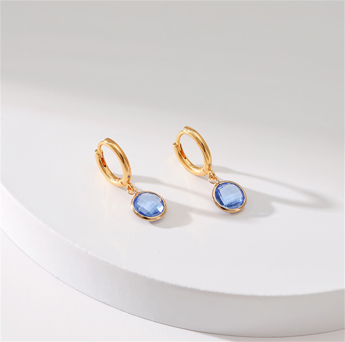 Chic 18K gold-plated huggie earrings embellished with blue topaz stones and purple crystals, perfect for any elegant occasion.