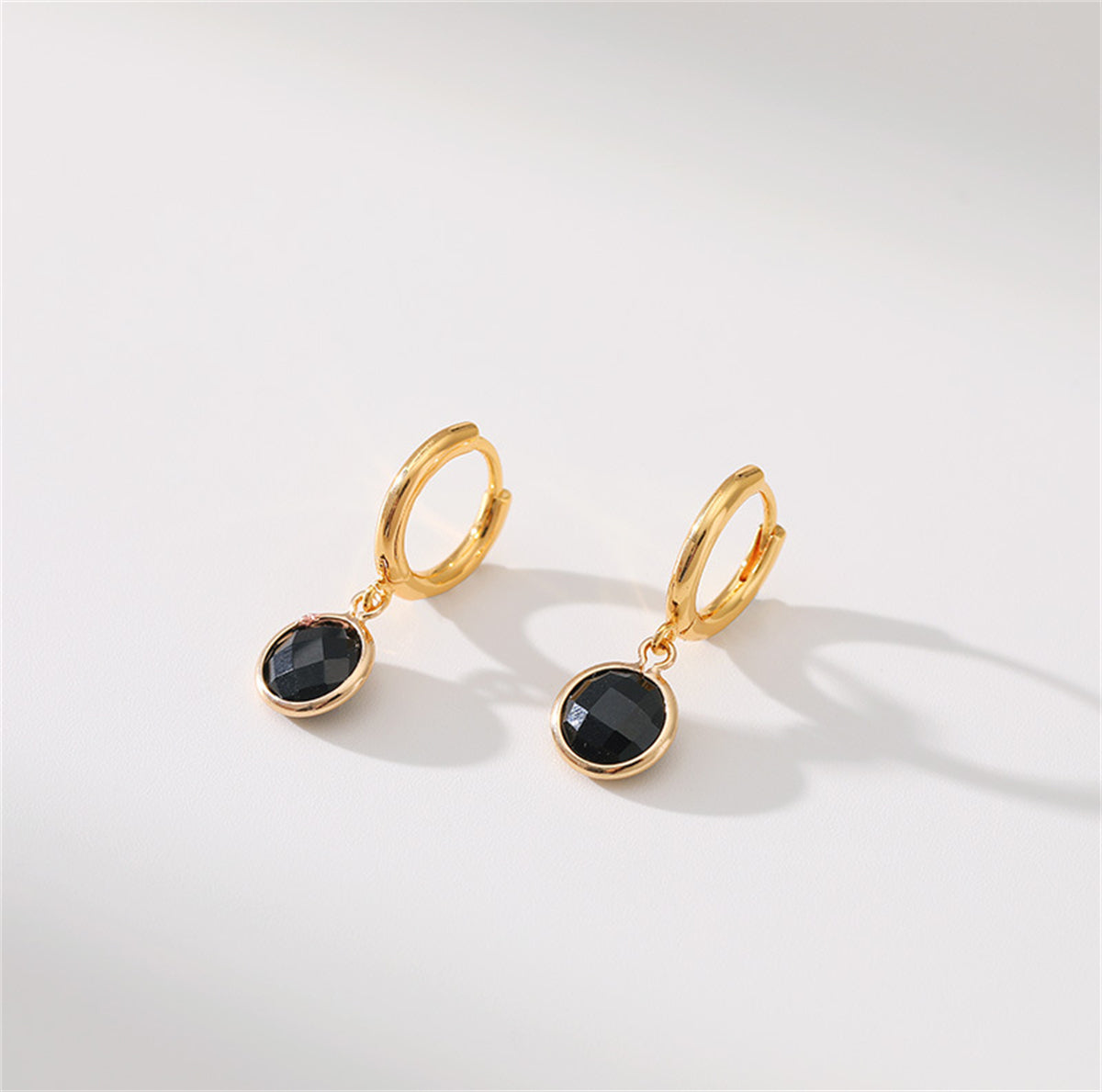 Chic black crystal earrings in a hoop style, featuring a gold-plated finish for an elegant and modern appearance.