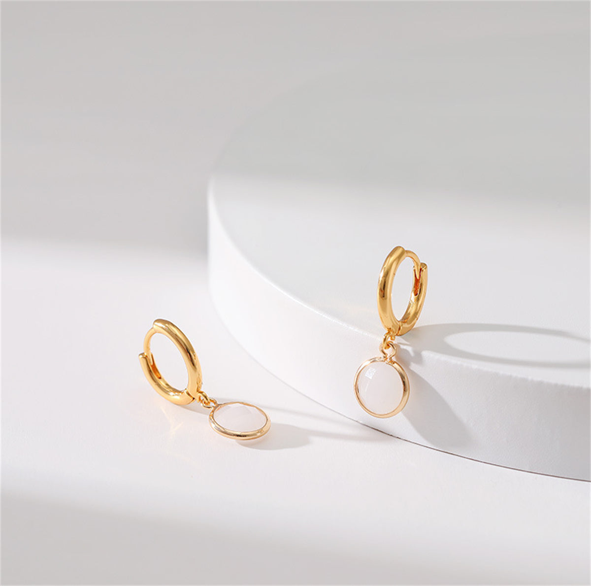 18K gold-plated round huggie earrings embellished with white crystal, showcasing a refined and stylish design.