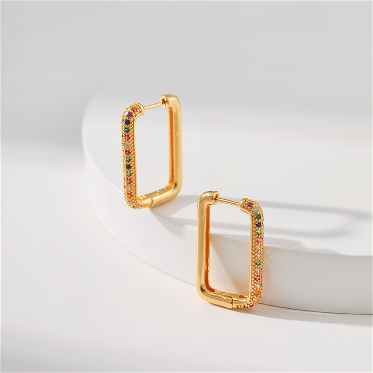 A pair of gold-plated square earrings embellished with multicolored cubic zirconia, offering a stylish and luxurious look.