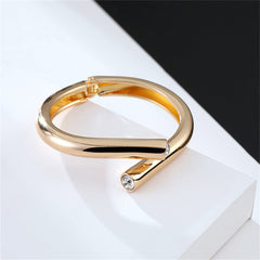 Elegant yellow gold bypass bangle adorned with two diamonds, crafted from cubic zirconia and 18K gold plating.