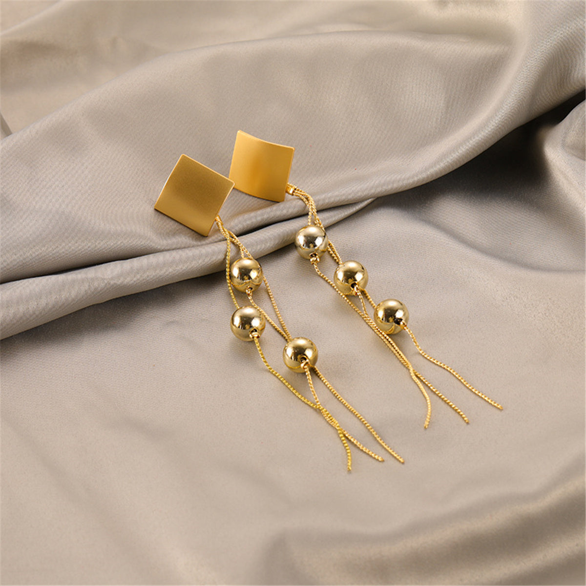 Stylish 18K gold-plated square earrings with a long chain, enhanced by beautiful diamond-shaped beaded tassels.