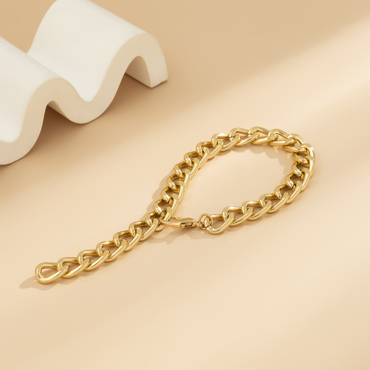 18K gold-plated curb chain bracelet accentuates its gleaming finish and modern appeal.