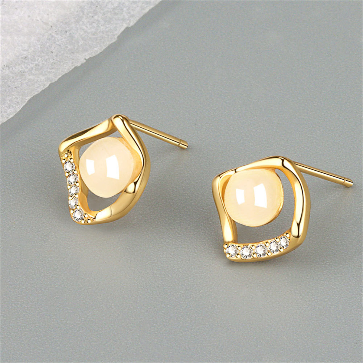 Dazzling 18K gold-plated stud earrings adorned with white stones, showcasing a chic rhombus shape for a stylish look.