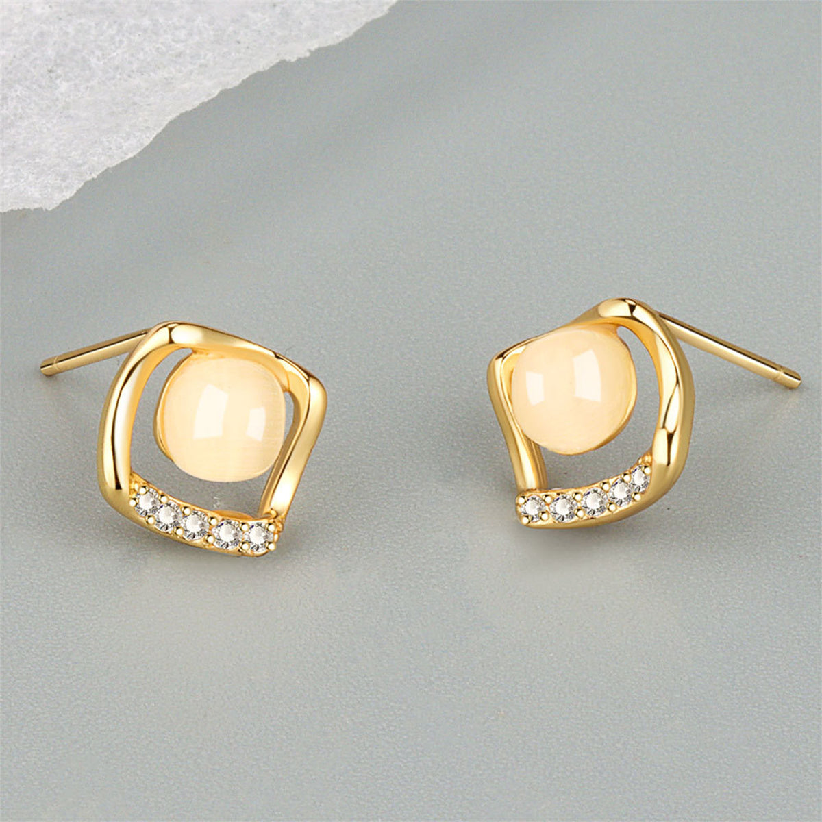 Beautiful gold-plated stud earrings with white cubic zirconia, designed in a rhombus shape for a touch of elegance.